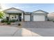 Attractive home showcasing a covered porch, landscaped front yard, and a two-car garage, combining curb appeal with practicality at 11656 N San Clemente St, Surprise, AZ 85388