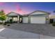 Charming home featuring a well-manicured lawn, stone accents, a covered porch, and a spacious two-car garage at 11656 N San Clemente St, Surprise, AZ 85388