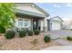 Inviting front porch with stone columns, cozy seating, and lush landscaping, offering a welcoming entrance to the home at 11656 N San Clemente St, Surprise, AZ 85388