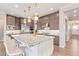 Gourmet kitchen features stainless steel appliances, large island, and designer pendant lighting at 11656 N San Clemente St, Surprise, AZ 85388