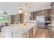 Open concept kitchen boasts stainless steel appliances, large island, and views of the living area at 11656 N San Clemente St, Surprise, AZ 85388