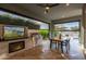 This outdoor patio with large fireplace, tv, dining table, and grill creates a luxurious living space at 11656 N San Clemente St, Surprise, AZ 85388