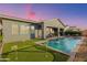 Beautiful backyard featuring a sparkling pool with fountain, a putting green, and a covered patio for outdoor entertaining at 11656 N San Clemente St, Surprise, AZ 85388