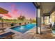 Inviting outdoor pool area with a fountain, lounge chairs, and a covered patio overlooking a manicured golf course at 11656 N San Clemente St, Surprise, AZ 85388