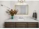 Traditional bathroom vanity with marble countertop, gray cabinets, and a decorative flower arrangement at 12633 N 81St St, Scottsdale, AZ 85260