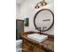 Quaint powder room with a unique sink and vanity, round mirror and industrial-style lighting at 12633 N 81St St, Scottsdale, AZ 85260