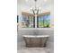 Luxurious bathroom features a freestanding tub under large windows with natural light at 12633 N 81St St, Scottsdale, AZ 85260
