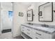 Bathroom featuring dual sinks with marble countertops, white cabinets, and a glass shower at 12633 N 81St St, Scottsdale, AZ 85260