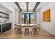 A dining room with wood flooring, beam ceilings, and large windows, adjacent to a bar area at 12633 N 81St St, Scottsdale, AZ 85260