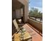 Relax on this covered balcony with seating, small table, and view of desert landscaping at 14645 N Fountain Hills Blvd # 208, Fountain Hills, AZ 85268