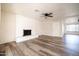 Spacious living room featuring a brick fireplace, ceiling fan, and wood-look flooring, offering modern comfort at 1633 E Wesleyan E Dr, Tempe, AZ 85282