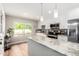 Modern kitchen featuring white cabinets, stainless steel appliances, an island, and decorative backsplash at 17822 N Del Webb Blvd, Sun City, AZ 85373
