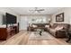 Comfortable living room with a plush sectional sofa, wood flooring, and a large flat-screen TV at 17822 N Del Webb Blvd, Sun City, AZ 85373