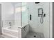 Bathroom featuring a bathtub, a glass-enclosed shower with black fixtures and stone flooring at 18374 W Stinson Dr, Surprise, AZ 85374
