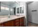 Bathroom featuring a double sink vanity, a large mirror, and a door to a private toilet at 18374 W Stinson Dr, Surprise, AZ 85374