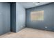 Bedroom featuring a large window, gray carpet flooring and blue-gray painted walls at 18374 W Stinson Dr, Surprise, AZ 85374