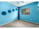 bedroom with blue walls, carpet flooring, one window and a set of floating shelves at 18374 W Stinson Dr, Surprise, AZ 85374