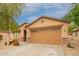 Single-story home featuring desert landscaping, a spacious driveway, and an attached two-car garage at 18374 W Stinson Dr, Surprise, AZ 85374
