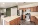 Modern kitchen with stainless steel appliances, an island with a white countertop, and laminate flooring at 18374 W Stinson Dr, Surprise, AZ 85374