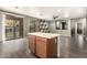 Kitchen island with laminated cabinets and a light countertop, opening up to a living area and pool access at 18374 W Stinson Dr, Surprise, AZ 85374