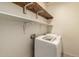 Functional laundry room featuring modern washing machine, dryer, and built-in white shelving at 18374 W Stinson Dr, Surprise, AZ 85374