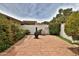 Private backyard featuring a brick patio, lush landscaping, and a cozy seating area at 18607 N 125Th Ave, Sun City West, AZ 85375