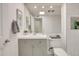 Updated bathroom features a modern vanity with gray cabinets and white countertops, complemented by a large mirror and tile accents at 18607 N 125Th Ave, Sun City West, AZ 85375