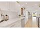 Open kitchen with white cabinets, stainless steel dishwasher, and plenty of countertop space at 18607 N 125Th Ave, Sun City West, AZ 85375