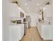 Modern kitchen boasts white cabinets, stainless steel appliances, and light wood flooring at 18607 N 125Th Ave, Sun City West, AZ 85375