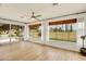 Inviting sunroom with wood-look tile, ceiling fan, and large windows offering picturesque views at 18607 N 125Th Ave, Sun City West, AZ 85375