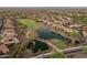 Scenic aerial view showcasing a community with a pond, golf course, and lush landscaping at 20289 N 259Th Ave, Buckeye, AZ 85396