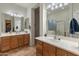 Spacious bathroom with double vanity sinks, wood cabinets, and large mirrors at 20289 N 259Th Ave, Buckeye, AZ 85396