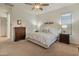 Bright bedroom featuring a large bed with decorative pillows, ceiling fan, and matching nightstands at 20289 N 259Th Ave, Buckeye, AZ 85396