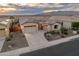 Charming single-Gathering home with a three car garage and beautiful desert landscaping at dusk at 20289 N 259Th Ave, Buckeye, AZ 85396