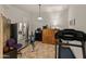 Well-lit fitness room with treadmill, rowing machine, refrigerator, and wooden storage at 20289 N 259Th Ave, Buckeye, AZ 85396