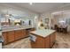 Well-lit kitchen showcasing wood cabinets, an island, stainless steel appliances and views through to the living room at 20289 N 259Th Ave, Buckeye, AZ 85396