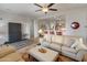 Open-concept living room with neutral sofas, a ceiling fan, and a view of the kitchen bar at 20289 N 259Th Ave, Buckeye, AZ 85396