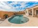 Beautiful backyard pool with travertine surround, waterfall feature, and covered patio at 20289 N 259Th Ave, Buckeye, AZ 85396