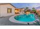 Beautiful backyard pool with travertine surround, outdoor kitchen and landscape lighting at 20289 N 259Th Ave, Buckeye, AZ 85396