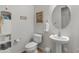 Charming powder room with pedestal sink, decorative mirror, and storage cabinet for a functional space at 20289 N 259Th Ave, Buckeye, AZ 85396