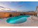 Sparkling pool with beautiful desert landscaping, serene waterfalls, and an inviting lounge chair at 20289 N 259Th Ave, Buckeye, AZ 85396