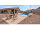 Inviting backyard featuring a refreshing private pool, dining area and desert landscaping at 23728 W Magnolia Dr, Buckeye, AZ 85326
