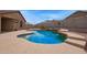 Lush, in-ground pool with unique stone accents and water features with desert landscaping at 23728 W Magnolia Dr, Buckeye, AZ 85326