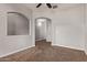 Neutral-toned bedroom with plush carpet, ceiling fan and archways at 23728 W Magnolia Dr, Buckeye, AZ 85326