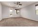 Spacious bedroom with plush carpet, neutral walls, a ceiling fan and a backyard view at 23728 W Magnolia Dr, Buckeye, AZ 85326