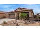 This single-story home features a covered porch and desert landscaping at 23728 W Magnolia Dr, Buckeye, AZ 85326