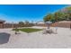 Expansive backyard featuring neutral rocks, a small lawn and dining set, perfect for outdoor relaxation and entertaining at 2377 S 245Th Dr, Buckeye, AZ 85326