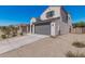 View of the property, featuring a two car garage door, a small yard, and desert landscaping at 2377 S 245Th Dr, Buckeye, AZ 85326