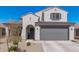 Stylish home featuring a grey two car garage door, an arched entry and desert landscaping at 2377 S 245Th Dr, Buckeye, AZ 85326