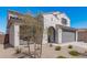 View of the property, featuring a two car garage door, an arched entry, and minimal desert landscaping at 2377 S 245Th Dr, Buckeye, AZ 85326